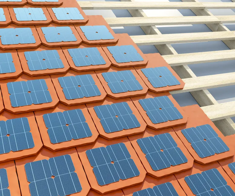 Conceptual close-up of a residential roof with terracotta-colored tiles, showing blue square solar panels designed to be integrated seamlessly into the tile structure.