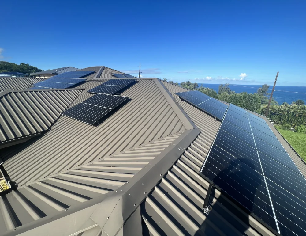 Solar panel installation on a modern metal roof with an ocean view, showing a clean and efficient residential solar setup.